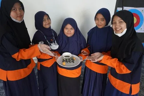 Murid SD menunjukkan hasil karyanya bersama teman sekelas