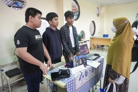 Murid SMP menjaga stan karyanya pada Expo Day sekolah